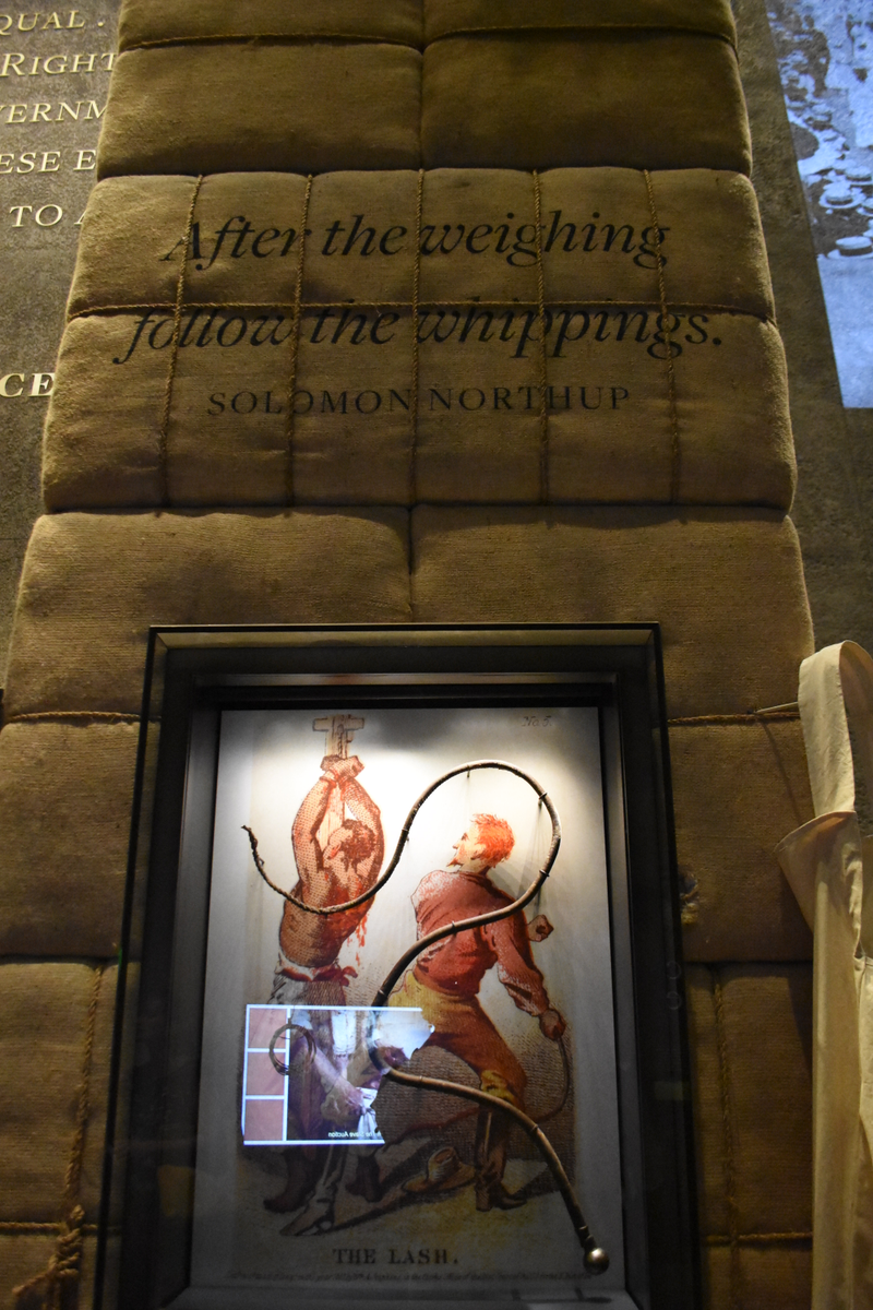 A whip enclosed in a glass case under the quote, āAfter the weighing follow the whippings.ā āSolomon NorthupVeronica Graves/The Root